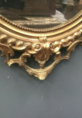 Miroir ovale a fronton en bois et stuc doré